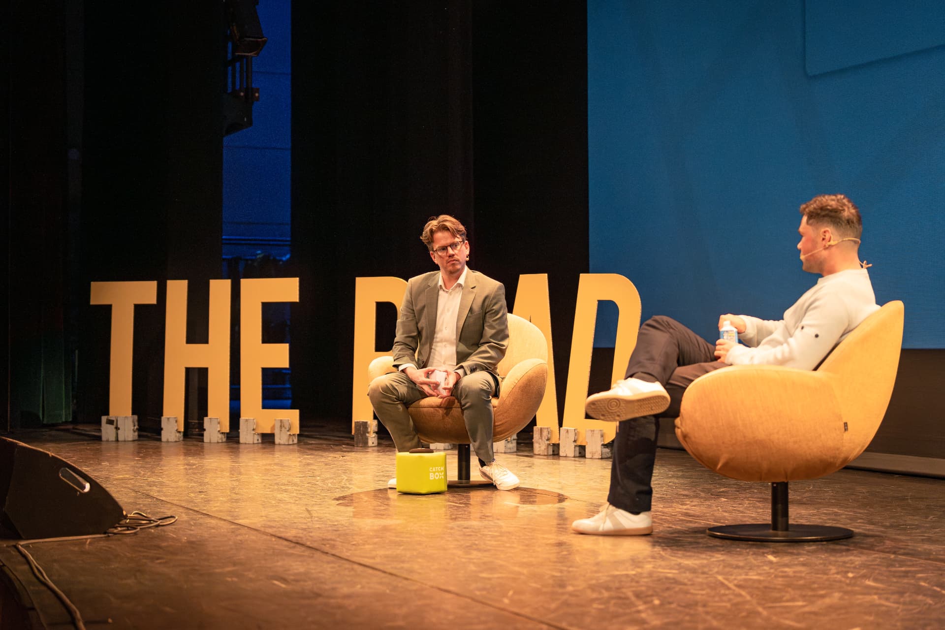 Jerre Maas in gesprek met een gast in de gele stoelen bij The Road