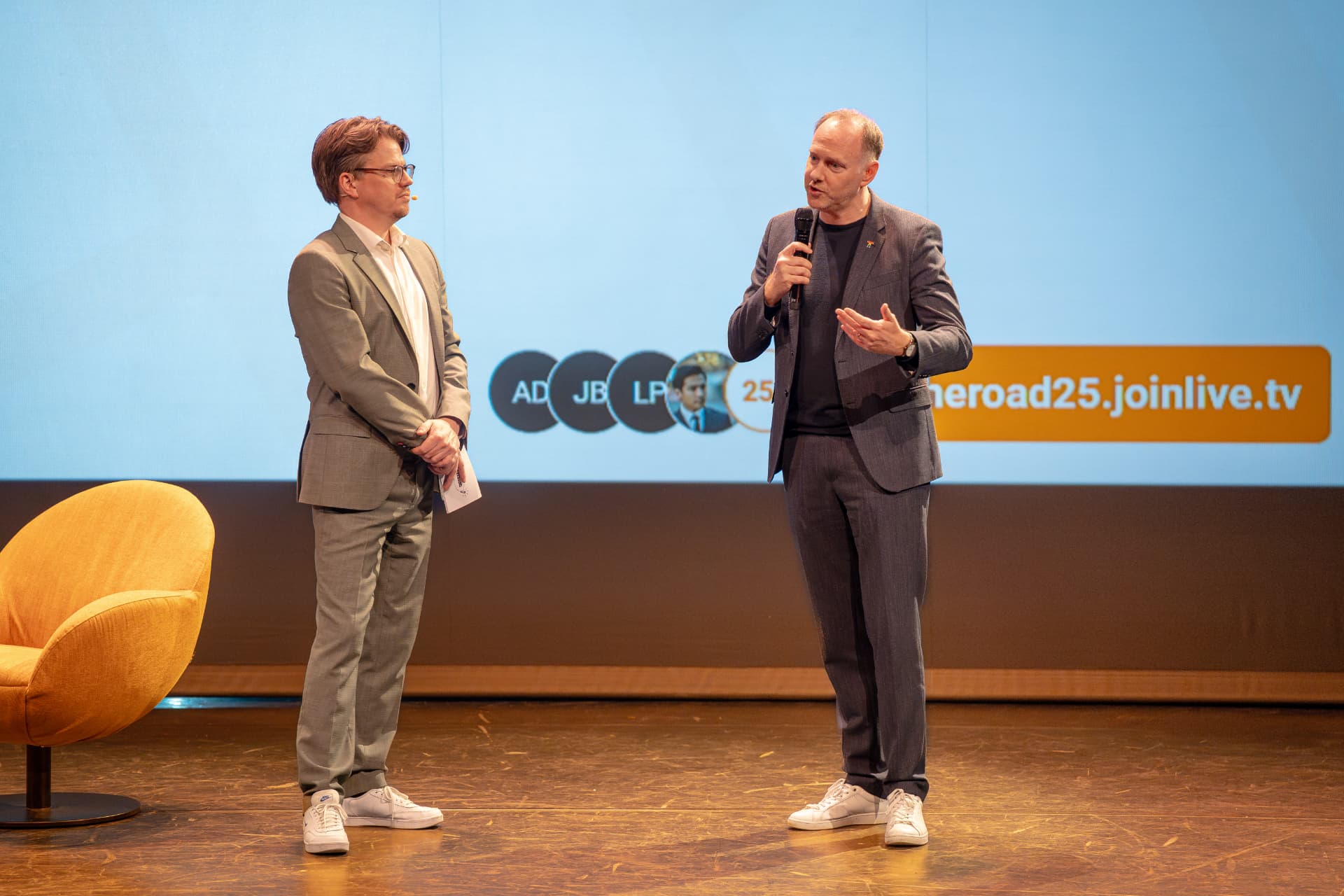 Jerre Maas en een spreker voor een scherm met de link om live mee te doen