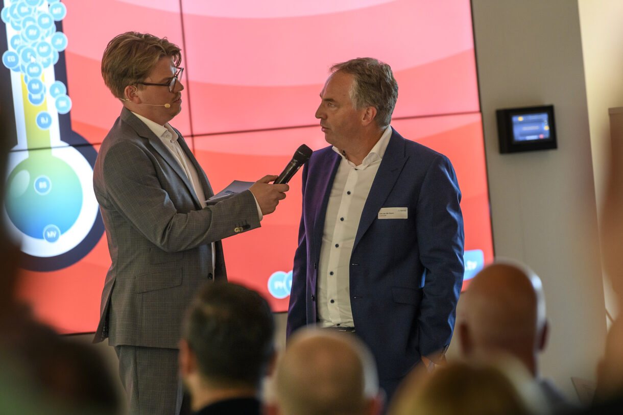 Jerre Maas interviewt een gast op het podium bij VNO-NCW