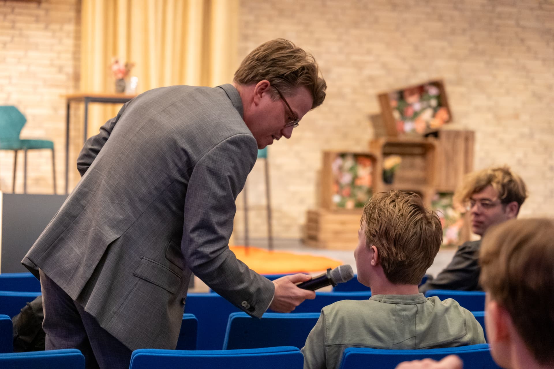 Jerre Maas houdt de microfoon voor een student in de zaal