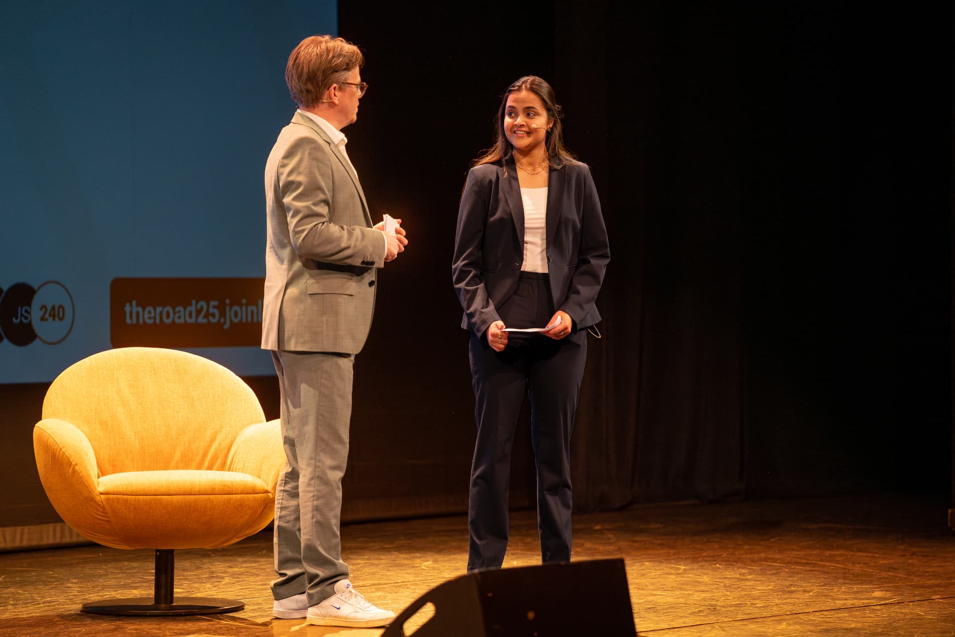 Jerre Maas presenteert samen met een co-host op het podium bij The Road