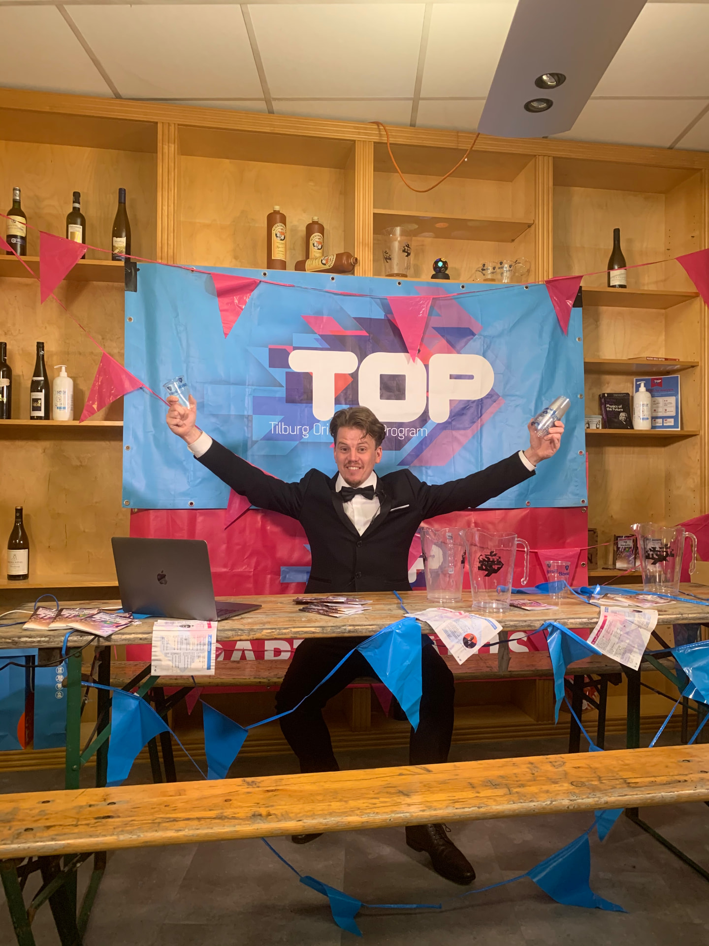 Jerre Maas als quizmaster met armen omhoog bij een quiz in Tilburg